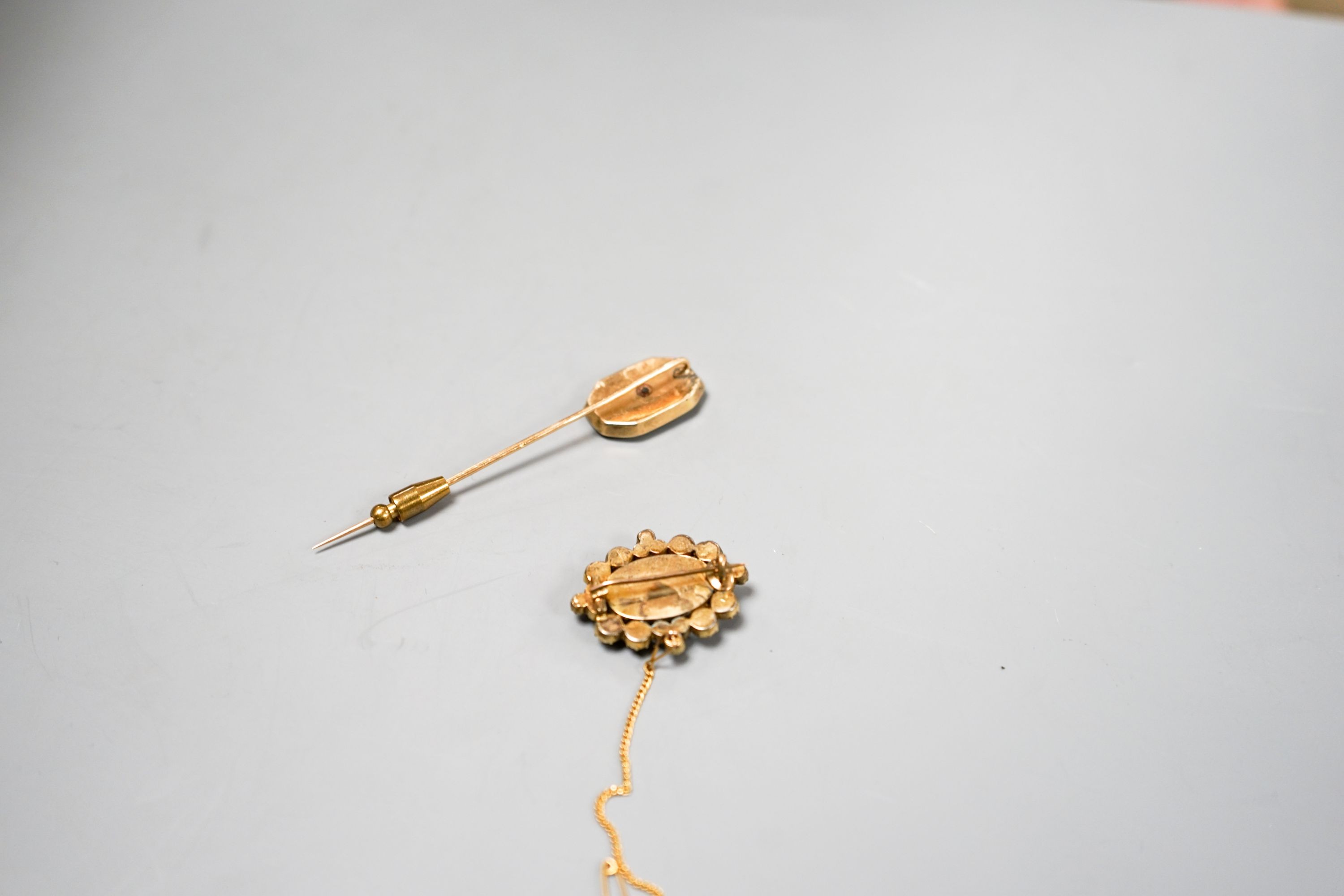 A Victorian yellow metal, amethyst and split pearl set brooch, 31mm and a stick pin.